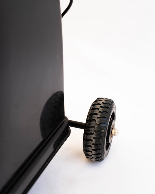 Close-up of a wheel attached to a black rectangular object on a white background